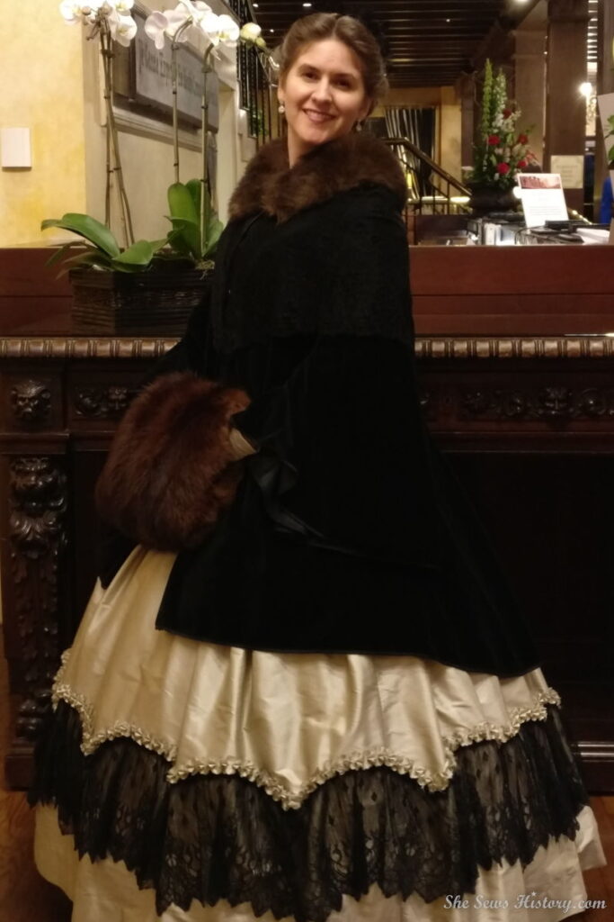 Black velvet pardessus worn over ball gown with sable fur muff and collar
