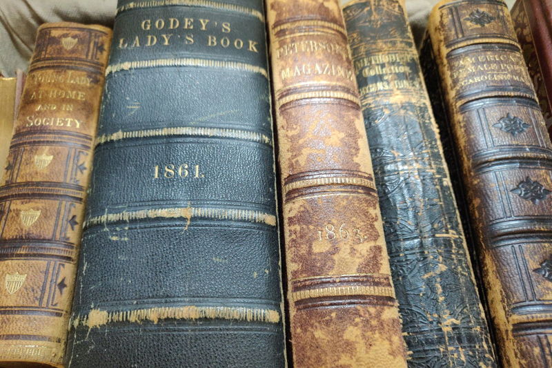 A stack of Old Books including Godey's Lady's Book 1861 