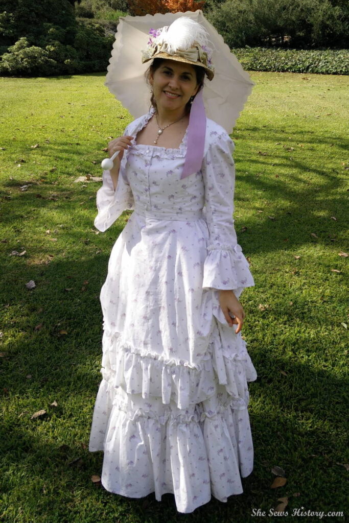 Girl in White 1870 Victorian Bustle dress straw hat and parasol